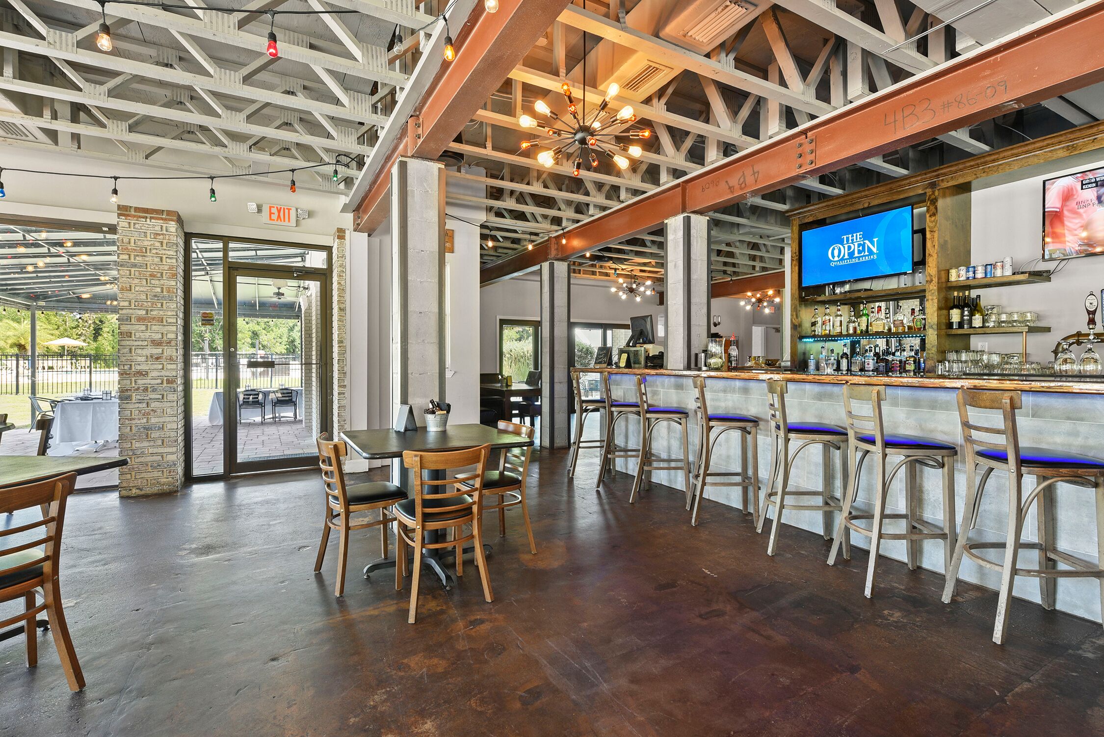 Photo of a bar with natural lighting and a mix of high and low tables