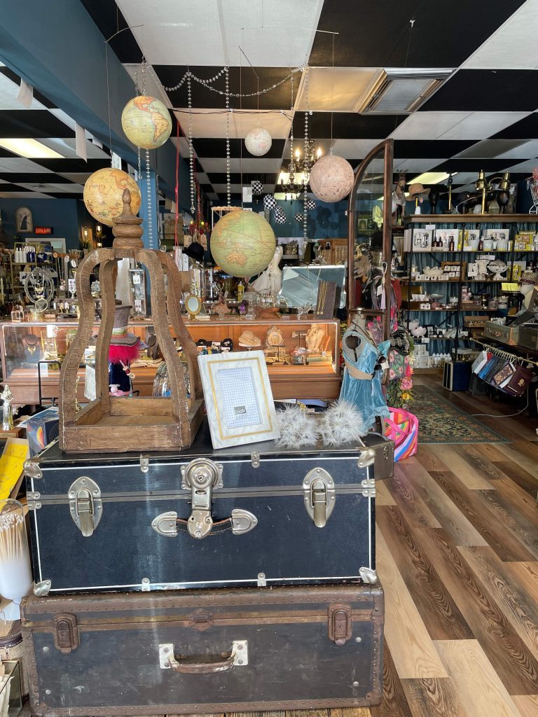 Shop image includes vintage suitcases and globles hanging from the ceiling