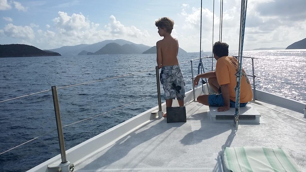 Dad and son sitting on a sailboat looking out of the water on the Nepenthe Sailing Boat