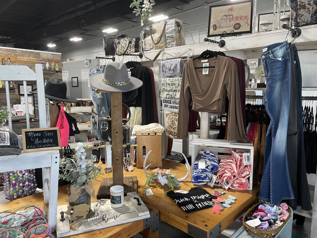 Inside of key to glam boutique with a display of clothing jewelry and trinkets