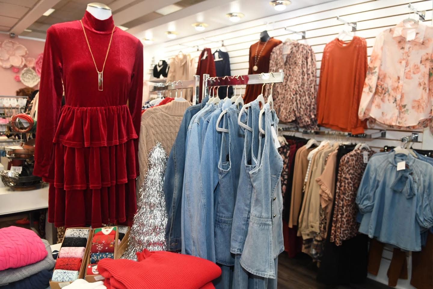 interior of a clothing store with dresses on a mannequin and hanging on the walls