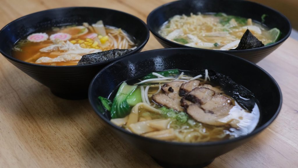 three bowls of ramen on a table