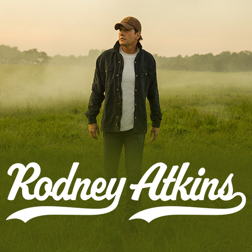 Artist, Rodney Atkins, standing in a grass field.
